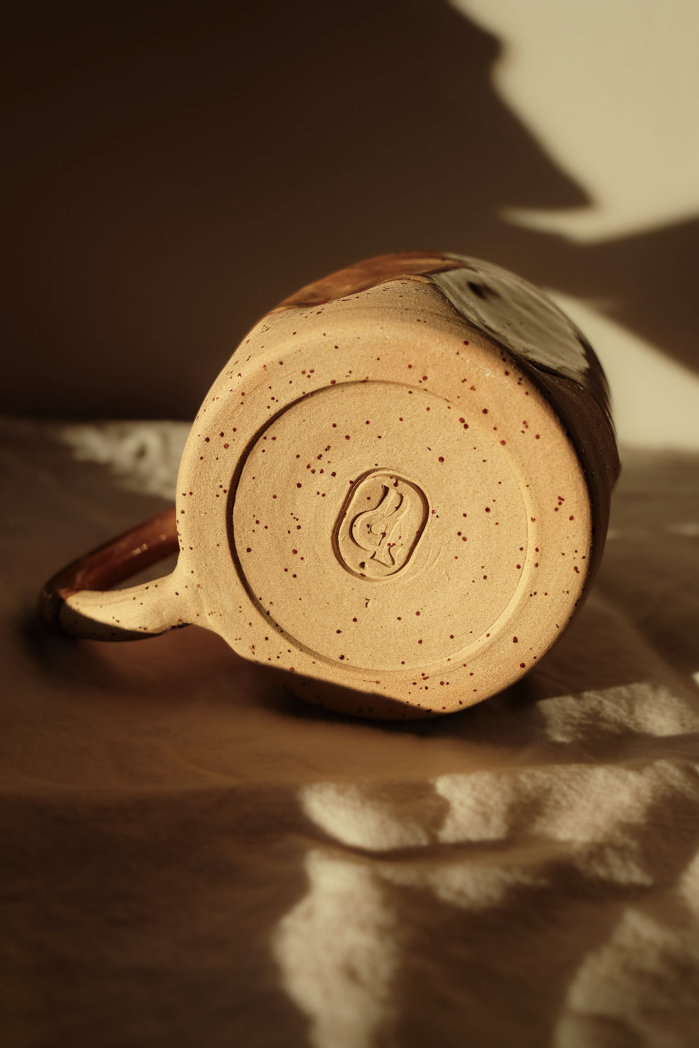 Détail d’une tasse en céramique artisanale émaillée caramel, pièce unique de la collection Détails x Ollaemporium