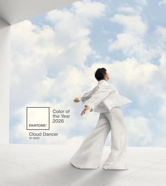 Visuel Pantone présentant la couleur de l’année 2026, Cloud Dancer (11-4201) : une silhouette vêtue de blanc évolue dans un espace minimaliste, face à un ciel lumineux parsemé de nuages, évoquant légèreté, douceur et mouvement.