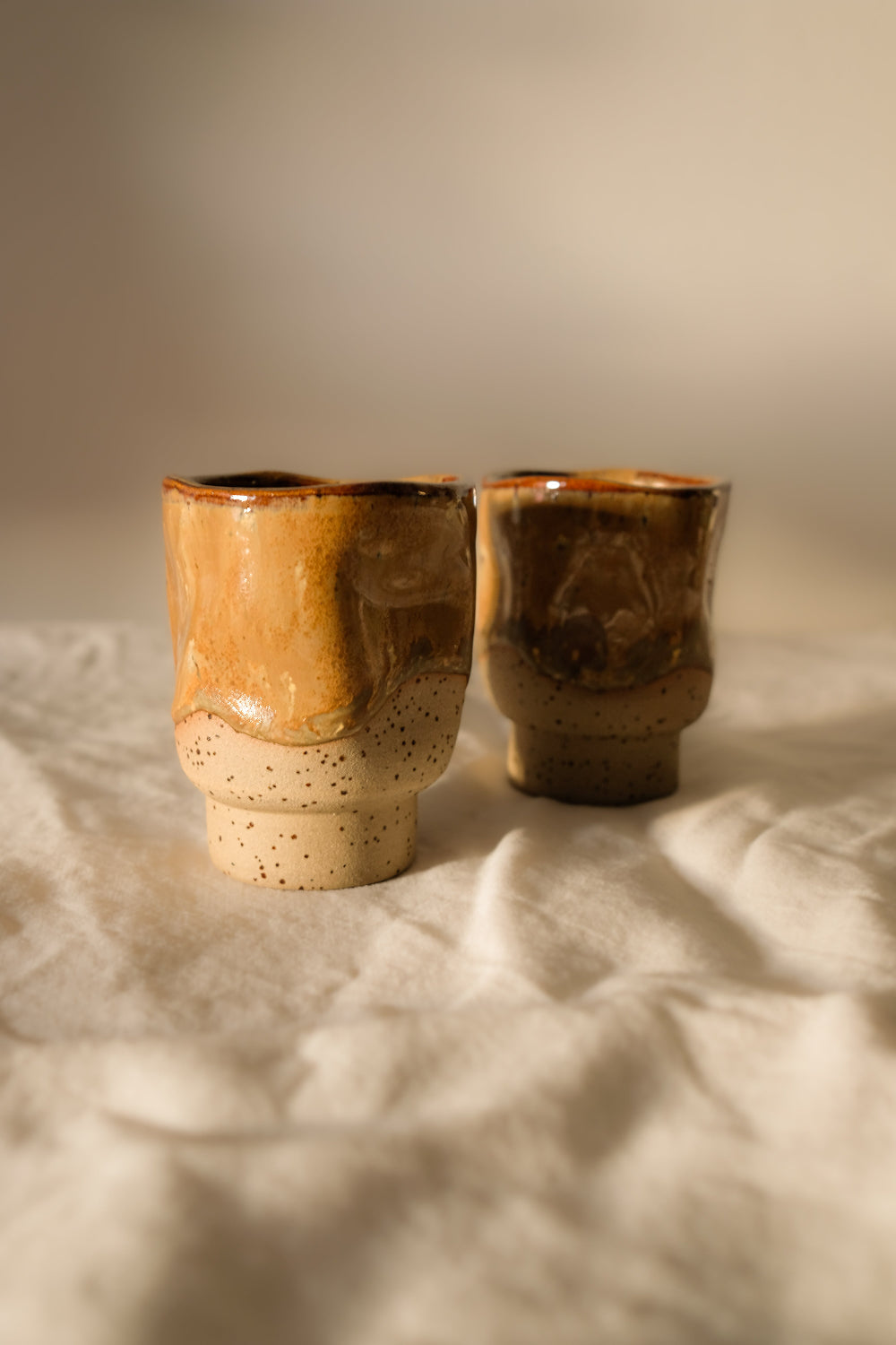 Détail de deux tasses espresso en céramique artisanale française, façonnées et émaillées à la main, nuances café et caramel, collection Détails x Ollaemporium.